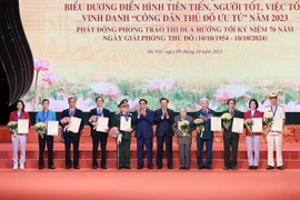 Thủ tướng Phạm Minh Chính và Bí thư Thành ủy Hà Nội Đinh Tiến Dũng trao danh hiệu 'Công dân Thủ đô Ưu tú' năm 2023 cho các cá nhân. (Ảnh: Dương Giang/TTXVN)