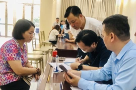 Làm thủ tục trao kinh phí hỗ trợ đợt 2 cho các nạn nhân của vụ cháy. (Ảnh: Tuyết Mai/TTXVN)