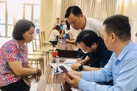 Làm thủ tục trao kinh phí hỗ trợ đợt 2 cho các nạn nhân của vụ cháy. (Ảnh: Tuyết Mai/TTXVN)