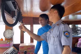 Kiểm ngư kiểm tra trang bị giám sát hành trình trên các tàu cá đang đánh bắt trên biển. (Ảnh: TTXVN phát)
