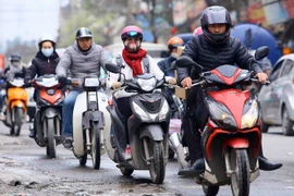 Trang phục kín mít của người dân khi ra đường để tránh rét. (Ảnh: Quang Quyết/TTXVN)