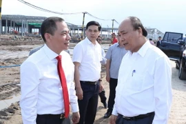Thủ tướng Nguyễn Xuân Phúc trao đổi với ông Phạm Nhật Vượng, Chủ tịch Hội đồng quản trị Tập đoàn Vingroup tại khu vực hạng mục đang được xây dựng của Nhà máy ôtô Vinfast. (Ảnh: Thống Nhất/TTXVN)