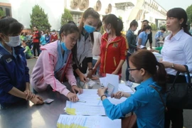 Tổ công tác được thành lập theo quyết định của Ủy ban Nhân dân tỉnh Đồng Nai tiếp tục trao tiền hỗ trợ cho những công nhân chưa nhận trước Tết. (Ảnh: Lê Xuân/TTXVN)