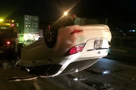 Chiếc ôtô con bị lật ngửa. (Ảnh: Tiến Vĩnh/TTXVN)