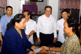 Phó Chủ tịch Thường trực Quốc hội Tòng Thị Phóng tặng quà hỗ trợ người dân bị mất nhà do sạt lở. (Ảnh: Thanh Liêm/TTXVN)
