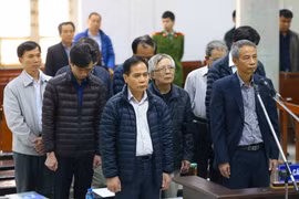 Bị cáo Hoàng Thế Trung (áo khoác màu đen đứng hàng đầu) và các bị cáo nghe tòa tuyên án. (Ảnh: Doãn Tấn/TTXVN)