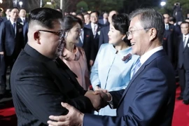 Nhà lãnh đạo Triều Tiên Kim Jong-un (trái) cùng phu nhân Ri Sol Ju (thứ 2, trái) và Tổng thống Hàn Quốc Moon Jae-in (phải) cùng phu nhân Kim Jung-sook (thứ 2, phải) chào từ biệt tại làng đình chiến Panmunjom tối 27/4. (Nguồn: YONHAP/TTXVN)