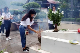 Thanh niên, sinh viên kiều bào tiêu biểu thắp hương tại khu mộ 10 liệt sỹ thanh niên xung phong tại Khu di tích Ngã ba Đồng Lộc. (Ảnh: Công Tường/TTXVN)
