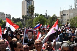 Người dân Syria đã đổ xuống đường phố Aleppo, bày tỏ sự ủng hộ Tổng thống Bashar al-Assad và quân đội Chính phủ, ngày 14/4. (Nguồn: AFP/TTXVN)