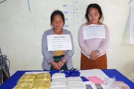 Hai đối tượng Nàng Dua Mua và Nàng May Hơ cùng tang vật vụ án. (Ảnh: Trịnh Duy Hưng/TTXVN)