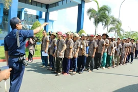 Các ngư dân xếp hàng làm thủ tục trao trả ở Indonesia. (Ảnh: Đỗ Quyên/TTXVN)