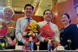 Lãnh đạo Thành phố Hồ Chí Minh tặng hoa và chúc mừng sự đoàn tụ của gia đình bà Diệp Tú Anh (bìa trái), nguyên là chiến sỹ biệt động thành và 2 con trai Diệp Tuấn (thứ 2, từ trái) và Diệp Dũng (giữa) tại buổi họp mặt. (Ảnh: Thế Anh/TTXVN)