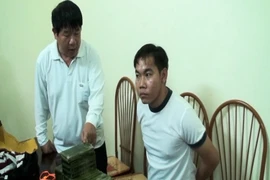 Đối tượng Khăm Phụt Thăm Mạ Vông cùng vật chứng tại cơ quan điều tra. (Ảnh: Xuân Tư/TTXVN)