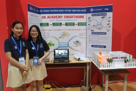 Gia Linh và Yến Nhi bên mô hình dự án Ứng dụng Board Arduino thiết kế mạch điều khiển các thiết bị điện trong nhà. (Nguồn: Vietnam+)