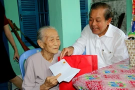 Phó Thủ tướng Thường trực Chính phủ Trương Hòa Bình tặng quà Tết cho bà Lê Thị Sử, cư trú tại phường Thanh Hải, thành phố Phan Thiết, tỉnh Bình Thuận. (Ảnh: Nguyễn Thanh/TTXVN)