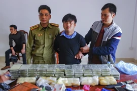 Đối tượng Giàng A Tú và tang vật của vụ án tại cơ quan điều tra. (Ảnh: Xuân Tiến/TTXVN)