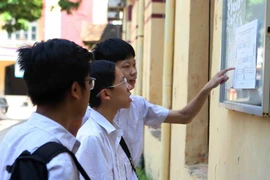 Thí sinh xem số báo danh, sơ đồ phòng thi tại điểm thi Trường trung học phổ thông Trần Phú. (Ảnh: Thanh Tùng/TTXVN)