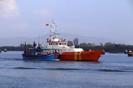 Tàu SAR 413 lai dắt tàu cá QNg 98366 TS về bờ. (Ảnh: Đoàn Mạnh Dương/TTXVN)