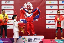 Vận động viên Việt Nam Thạch Kim Tuấn (trái) giành huy chương bạc, Om Yun Chol (giữa) của Triều Tiên giành huy chương vàng và Surahmat Bin Suwoto Wijoyo của Indonesia giành huy chương đồng nội dung cử tạ hạng 56kg. (Nguồn: AFP/ TTXVN