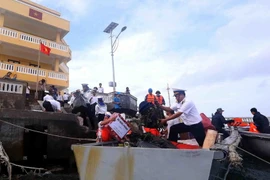 Vận chuyển hàng quà, nhu yếu phẩm vào đảo Núi Le A. (Ảnh: Quang Quyết/TTXVN)
