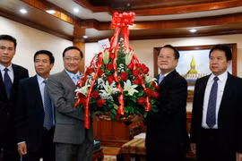 Ông Nguyễn Bá Hùng đang trao cho ông Somdy Bounkhoun lẵng hoa chúc mừng của Tổng Bí thư Nguyễn Phú Trọng gửi Tổng Bí thư, Chủ tịch nước Lào Bounnhang Volachith. (Ảnh: Phạm Kiên/Vietnam+)