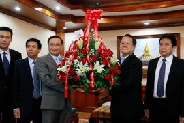 Ông Nguyễn Bá Hùng đang trao cho ông Somdy Bounkhoun lẵng hoa chúc mừng của Tổng Bí thư Nguyễn Phú Trọng gửi Tổng Bí thư, Chủ tịch nước Lào Bounnhang Volachith. (Ảnh: Phạm Kiên/Vietnam+)