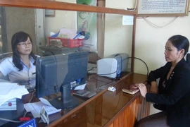 Người dân giao dịch tại một điểm Quỹ tín dụng nhân dân trên địa bàn tỉnh Quảng Bình. (Ảnh: Đức Thọ/TTXVN)