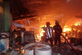 Cảnh sát phòng cháy chữa cháy nỗ lực dập lửa. (Ảnh: Thành Chung/TTXVN)