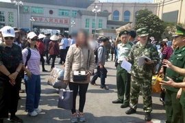 Lực lượng chức năng Việt Nam tiếp nhận chị O nạn nhân bị lừa bán từ phía lực lượng chức năng Trung Quốc. (Ẩnh: Nguyễn Hoàng/TTXVN)