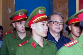Dẫn giải bị cáo Phạm Công Danh ra xét xử tại phiên tòa. (Ảnh: Hoàng Hải/TTXVN)