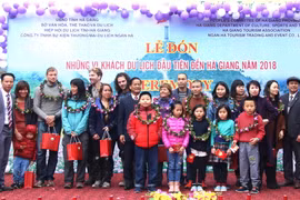 Lãnh đạo Sở Văn hóa, Thể thao và Du lịch Hà Giang trao tặng quà lưu niệm cho những vị khách du lịch quốc tế đầu tiên đến với Hà Giang năm 2018. (Ảnh: Văn Long/TTXVN phát)