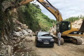 Phương tiện qua lại ở điểm sạt lở đất đá trên tuyến Quốc lộ 279D đã được thông xe bước 1. (Nguồn: TTXVN phát)