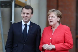 Tổng thống Pháp Emmanuel Macron (ảnh, trái) thăm và làm việc với Thủ tướng Đức Angela Merkel (ảnh, phải) tại thủ đô Berlin, ngày 19/4. (Nguồn: THX/TTXVN)