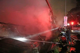 Lực lượng cảnh sát phòng cháy chữa cháy tiếp cận hiện trường vụ hoả hoạn. (Ảnh: Nguyễn Dũng/TTXVN)