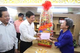Chủ tịch Ủy ban Nhân dân Thành phố Hồ Chí Minh Nguyễn Thành Phong thăm, tặng quà gia đình liệt sỹ Lê Quang Lộc. (Ảnh: Thanh Vũ/TTXVN)