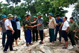 Thứ trưởng Bộ Nông nghiệp và Phát triển Nông thôn Hoàng Văn Thắng thăm hỏi, động viên, tặng quà hỗ trợ cho hộ gia đình bị thiệt hại nặng nề do mưa lũ ở thôn Tham Còn, xã Cao Bồ thuộc huyện Vị Xuyên, tỉnh Hà Giang. (Ảnh: Minh Tâm/TTXVN)