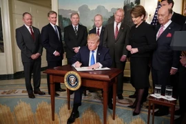 Tổng thống Mỹ Donald Trump ký một sắc lệnh tại Washington, DC ngày 22/3. (Nguồn: AFP/TTXVN)