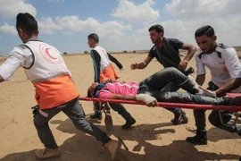 Chuyển người biểu tình Palestine bị thương sau các cuộc đụng độ với binh sỹ Israel tại khu vực biên giới Dải Gaza với Israel ngày 14/5. (Nguồn: AFP/TTXVN)
