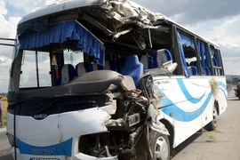 Chiếc xe khách bị hư hỏng nặng phần đầu đã được đưa ra khỏi hiện trường. (Ảnh: Tá Chuyên/TTXVN)