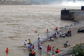 Người dân tắm sông khi Thủy điện Hòa Bình xả Lũ. (Ảnh: Thanh Hải/TTXVN)