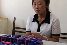 Đối tượng Mùa Thị Kẹo cùng tang vật. (Ảnh: Nguyễn Cường/TTXVN)