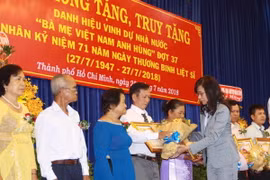 Bà Nguyễn Thị Thu, Phó Chủ tịch Ủy ban Nhân dân Thành phố Hồ Chí Minh trao bằng truy tặng danh hiệu Bà mẹ Việt Nam Anh hùng cho người thân của Mẹ. (Ảnh: Thanh Vũ/TTXVN)