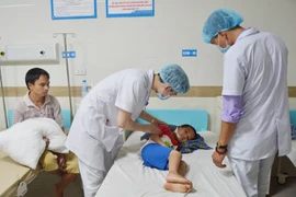 Các bác sỹ thăm khám cho cháu S. (Ảnh: Trung Kiên/TTXVN)