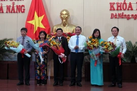 Bí thư Thành ủy Đà Nẵng Trương Quang Nghĩa tặng hoa cho các đại biểu vừa được bầu giữ chức vụ chủ chốt. (Ảnh: Nguyễn Sơn/TTXVN)