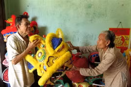 Vợ chồng nghệ nhân Nguyễn Tô (80 tuổi) và bà Trần Thị Tuyết (78 tuổi) với những sản phẩm lân truyền thống. (Ảnh: Phước Ngọc/TTXVN)