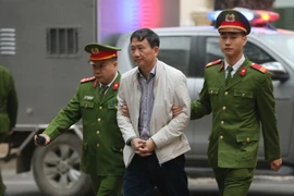 Cảnh sát dẫn giải bị cáo Trịnh Xuân Thanh, nguyên Chủ tịch Hội đồng quản trị, Tổng Giám đốc PVC tới tòa, sáng 22/1. (Ảnh: Doãn Tấn/TTXVN)