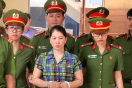 Dẫn giải bị cáo Hàng Thị Hồng Diễm đến tòa. (Nguồn: TTXVN)