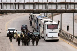 Đoàn xe sơ tán lực lượng nổi dậy và gia đình tại Đông Ghouta ngày 23/3. (Nguồn: THX/TTXVN)