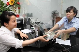 Khách hàng giao dịch tại Hội sở Co-op Bank, phố Nguyễn Thị Định (Hà Nội). (Ảnh: Trần Việt/TTXVN)