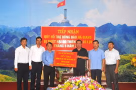 Phó Chủ tịch, Tổng Thư ký Ủy ban Trung ương Mặt trận Tổ quốc Việt Nam Hầu A Lềnh trao bảng tượng trưng một tỷ đồng của Ban cứu trợ Trung ương hỗ trợ đồng bào Hà Giang bị thiệt hại do mưa lũ. (Ảnh: Minh Tâm/TTXVN)